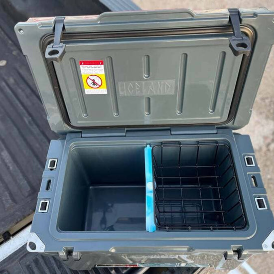 Open Iceland Cooler with Glacier Ice Pack and removable wire basket, shown on truck bed for outdoor use.