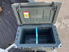 Open Iceland Cooler with Glacier Ice Pack and removable wire basket, shown on truck bed for outdoor use.