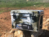 Camo-pattern Iceland Coolers Viking Series 45QT hard cooler placed on rocks in a rugged outdoor setting.